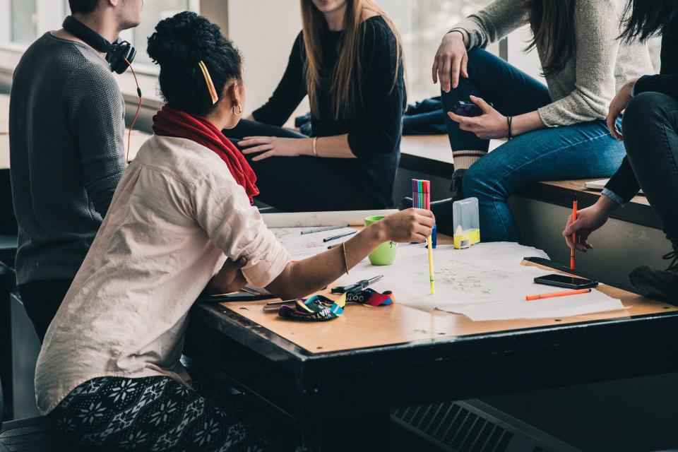 A small group of students working through options together at a table